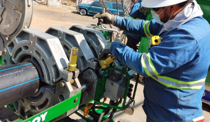 Operador de IMAC ajustando un equipo McElroy durante el proceso de termofusión de tubería de polietileno de alta densidad (PEAD) en un proyecto de infraestructura.