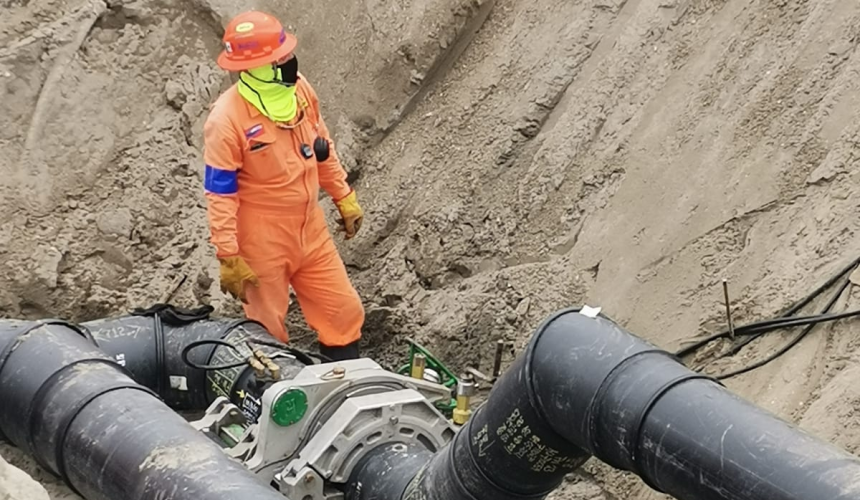 Especialista realizando la termofusión de un codo de tubería PEAD con equipo McElroy durante la instalación de una red hidráulica en un proyecto de infraestructura.